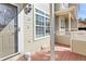 Inviting front porch with wood decking, neutral siding, and a stylish exterior light fixture and view of adjacent unit at 209 W Jamison Cir # 32, Littleton, CO 80120