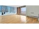 Bright living room with wood floors, a large mural, and floor-to-ceiling windows that provide ample natural light and balcony access at 955 Eudora St # 1106, Denver, CO 80220