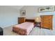 Bedroom with a pink floral bedspread, wooden furniture, and two framed pictures on the wall at 22580 E Ontario Dr # 202, Aurora, CO 80016