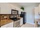 Well-lit kitchen boasting white cabinetry, stainless steel appliances, and a stone backsplash at 22580 E Ontario Dr # 202, Aurora, CO 80016