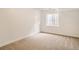 Clean and simple basement featuring neutral carpet and a small egress window at 6924 W Euclid Pl # A, Littleton, CO 80123