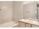 Well-lit bathroom featuring double vanity and a soaking tub with tiled accents at 6924 W Euclid Pl # A, Littleton, CO 80123