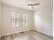 Bright bedroom with modern ceiling fan, stylish wood-look flooring, and plantation shutters at 6924 W Euclid Pl # A, Littleton, CO 80123