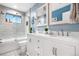 Bright bathroom features dual sinks, white marble tile and blue accent wall at 942 S County Road 129 Rd, Bennett, CO 80102