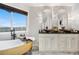 Elegant bathroom featuring dual vanities, decorative mirrors, and a freestanding tub with a view at 942 S County Road 129 Rd, Bennett, CO 80102