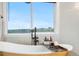 Bright, airy bathroom with a window view above a modern bathtub at 942 S County Road 129 Rd, Bennett, CO 80102