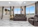 Bright living room featuring large windows, comfortable seating, and elegant marble flooring at 942 S County Road 129 Rd, Bennett, CO 80102