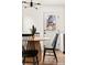 Bright dining area features a wood table, black chairs, modern light fixture, and an outdoor view at 133 S Xavier St, Denver, CO 80219