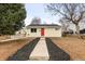 Inviting single-story home with a vibrant red door, contrasted with a well-maintained front yard at 133 S Xavier St, Denver, CO 80219