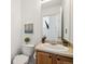 Cozy half bathroom with wood cabinets and a large mirror at 14881 E 117Th Ave, Commerce City, CO 80603
