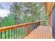 Wooden deck with black metal railings offering a scenic view of surrounding trees and natural landscape at 9209 William Cody Dr, Evergreen, CO 80439