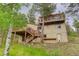 Backyard view with multiple wooden decks, a large yard, and an exterior door at 9209 William Cody Dr, Evergreen, CO 80439