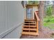 Side entrance of home with wood stairs and railing, leading to a screen door entry at 9209 William Cody Dr, Evergreen, CO 80439