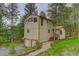 Charming home exterior featuring a two-car garage, quaint staircase and lush landscaping at 9209 William Cody Dr, Evergreen, CO 80439
