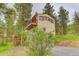 Exterior view of home's back and side, featuring deck and 2-story construction at 9209 William Cody Dr, Evergreen, CO 80439