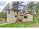 Exterior view of home's side and back, featuring yard, trees and 2-story construction at 9209 William Cody Dr, Evergreen, CO 80439