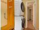 Compact laundry area with stacked washer and dryer and built in bench and storage at 9209 William Cody Dr, Evergreen, CO 80439
