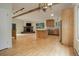 Open-concept living room with wood floors, stone fireplace, and updated kitchen at 9209 William Cody Dr, Evergreen, CO 80439