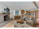 Spacious living room with a stone fireplace and a view into the kitchen at 9209 William Cody Dr, Evergreen, CO 80439