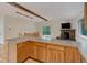 Open-concept living room featuring wood cabinets, stainless steel appliances, and a stone fireplace at 9209 William Cody Dr, Evergreen, CO 80439