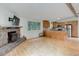 Open-concept living room with wood floors, stone fireplace, and an eat-in kitchen at 9209 William Cody Dr, Evergreen, CO 80439