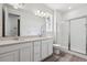 Elegant bathroom featuring double sinks, quartz countertops, and a glass enclosed shower at 19040 E 96Th Pl, Commerce City, CO 80022