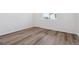 Bright bedroom with modern, light-colored wood flooring and ample natural light from a window at 19040 E 96Th Pl, Commerce City, CO 80022