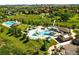 Aerial view showcases a community pool, water slides, and recreational facilities nestled within a well-maintained neighborhood at 9556 Kemper Dr, Lone Tree, CO 80124