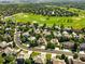 Picturesque aerial view of a residential neighborhood backing onto a lush green golf course with winding fairways and ponds at 9556 Kemper Dr, Lone Tree, CO 80124
