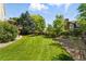 Well-maintained backyard features a spacious lawn, lovely landscaping, and a charming fence at 9556 Kemper Dr, Lone Tree, CO 80124