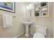 Bright bathroom with pedestal sink, decorative shelf, and tile floors at 9556 Kemper Dr, Lone Tree, CO 80124