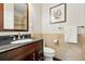 Functional bathroom with a wood vanity, black countertop, modern fixtures, and a tiled backsplash offers essential comfort at 9556 Kemper Dr, Lone Tree, CO 80124