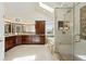 Luxurious bathroom with a glass-enclosed shower, a soaking tub, dual sinks, and a skylight provides a spa-like retreat at 9556 Kemper Dr, Lone Tree, CO 80124