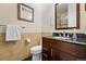 Practical bathroom with a single wood vanity, black countertop, a framed mirror, and neutral tiling offers convenience at 9556 Kemper Dr, Lone Tree, CO 80124