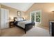 Cozy bedroom with a black bed frame, a window with natural light, and neutral wall color offers a serene retreat at 9556 Kemper Dr, Lone Tree, CO 80124