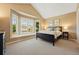Inviting bedroom with a bay window, a dark bed frame, neutral walls, and carpet offer comfort and style at 9556 Kemper Dr, Lone Tree, CO 80124