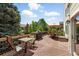 Large deck with multiple seating areas, grill, and lush trees at 9556 Kemper Dr, Lone Tree, CO 80124