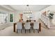 Bright dining room features a modern light fixture, stairway, and a large window providing ample natural light at 9556 Kemper Dr, Lone Tree, CO 80124