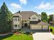 Stunning two-story home featuring a manicured lawn and a three-car garage at 9556 Kemper Dr, Lone Tree, CO 80124