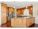 A view of the kitchen showcasing a granite island, custom cabinets, and stainless steel appliances with natural lighting at 9556 Kemper Dr, Lone Tree, CO 80124