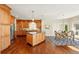 Gourmet kitchen with island, granite countertops, stainless steel appliances, and dark hardwood flooring, connecting to the dining area at 9556 Kemper Dr, Lone Tree, CO 80124