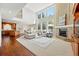Expansive living room boasts a brick fireplace, soaring ceilings, and large windows, all with hardwood floors and an open floorplan at 9556 Kemper Dr, Lone Tree, CO 80124