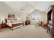 Spacious main bedroom with vaulted ceilings, a chandelier, a sitting area, and a large window offers comfort and style at 9556 Kemper Dr, Lone Tree, CO 80124
