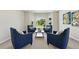 Cozy sitting room features four plush blue chairs arranged around a center table, bay window, and a decorative painting at 9556 Kemper Dr, Lone Tree, CO 80124