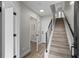 Inviting entryway featuring a staircase with black railings, light wood floors, and access to a convenient half bath at 3820 Jason St # 3, Denver, CO 80211
