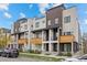 Modern townhomes featuring brick accents, balconies, and rooftop decks under a bright blue sky at 3820 Jason St # 3, Denver, CO 80211