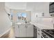 Bright kitchen features white cabinetry, quartz countertops, modern fixtures, and an eat-in nook with city views at 3820 Jason St # 3, Denver, CO 80211