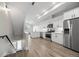 Open-concept kitchen with white cabinets, stainless steel appliances, and hardwood floors, perfect for modern living at 3820 Jason St # 3, Denver, CO 80211