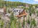 Aerial view showcasing the home's exterior, wooden decks, and surrounding wooded landscape at 11766 Coal Creek Heights Dr, Golden, CO 80403