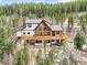 Aerial view showcases the home's exterior, wooden decks, and surrounding wooded landscape at 11766 Coal Creek Heights Dr, Golden, CO 80403